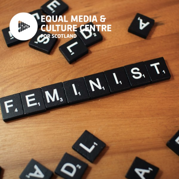A scrabble game on a table, where the word 'feminist' is spelled out in game pieces