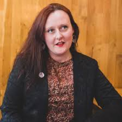 A photograph of Louise Oliver, a white woman with long brown hair