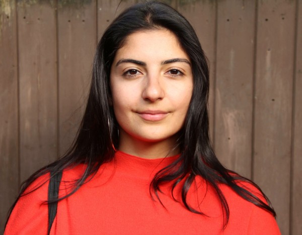photograph of loa pour mirza a woman of the global majority with long black hair and wearing a red top